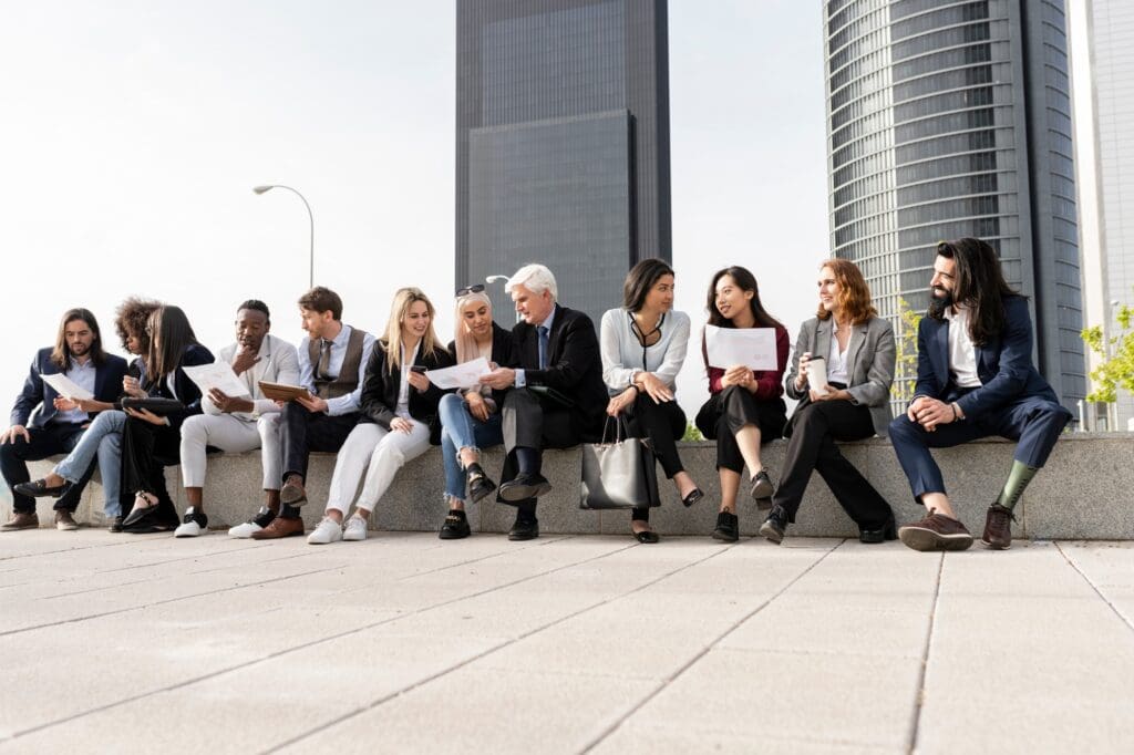 large group of multiracial businessmen of different ages, in the city, a meeting outdoors.